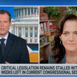 Two news anchors discuss stalled congressional legislation on a split-screen TV broadcast.